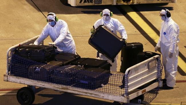 Workers load the luggage on the plane that will transport the passengers from the Australian cruise ship Greg Mortimer, at the international airport in Montevideo.