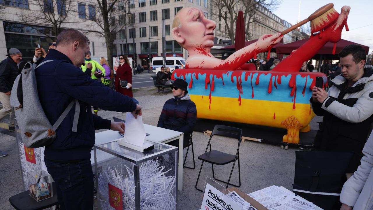 Protesters in Germany held a mock election where ballot papers were fed into paper shredders as an effigy of Putin bathes in a bloodbath. Picture: Sean Gallup/Getty Images