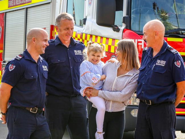 Lily enjoys a visit from Firefighters Antony Crowe, Brad Derch, and her grandfather fellow firefighter Andrew Wheeler Picture: Angelo Velardo