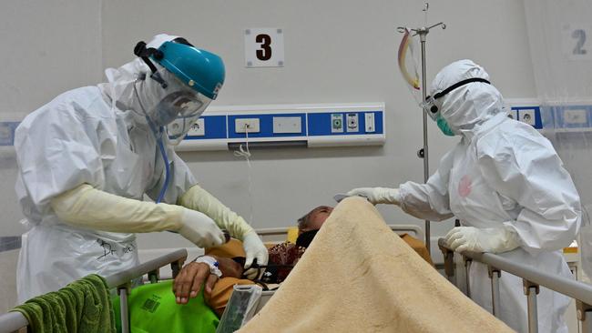 Nurses tend to a COVID-19 coronavirus patient at the Bogor general hospital in Bogor city, West Java, Indonesia.