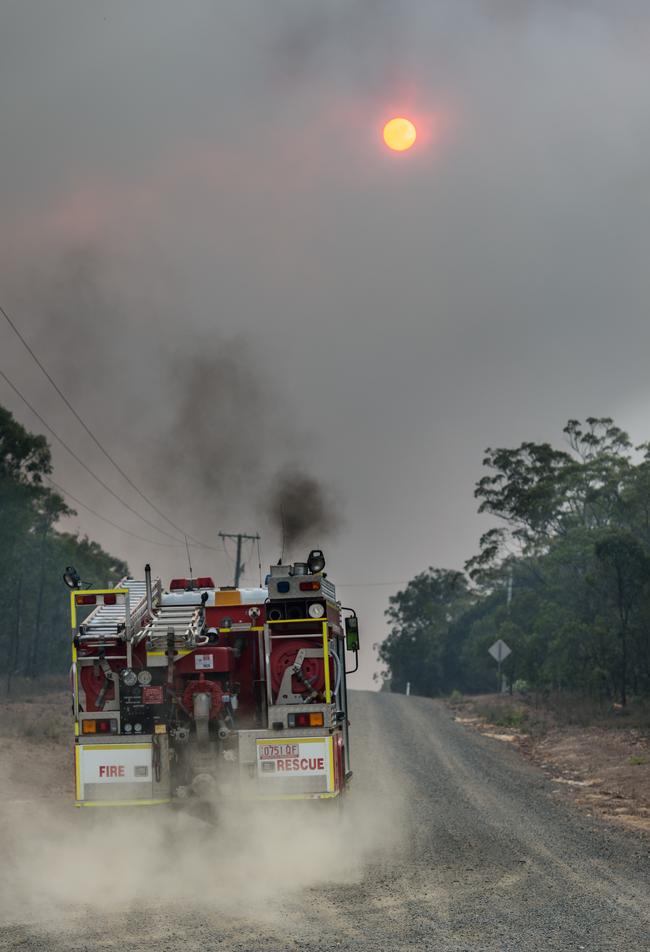 Firefighters head down Pacific Drive in Deepwater on Monday. Picture: Paul Beutel/AAP