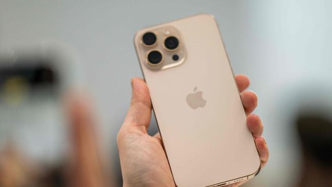 A person holds up a new iPhone 16 Pro following Apple's "It's Glowtime" event in Cupertino, California, September 9, 2024. (Photo by Nic COURY / AFP)