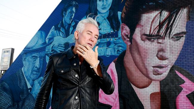 Director Baz Luhrmann poses for a photo in front of a giant Elvis Presley mural at Burleigh Heads in June. Picture: Scott Powick