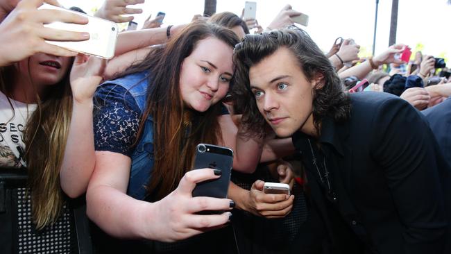 10th anniversary souvenir gold for this lucky fan with Harry on the 2014 ARIA red carpet. Picture: News Corp Australia