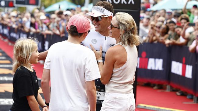 Braden Currie is congratulated by his children Bella Currie, 10, and Tarn Currie, 15, and his wife Sally Currie after crossing the finish line to win the Ironman Cairns Asia Pacific Championship. Picture: Brendan Radke