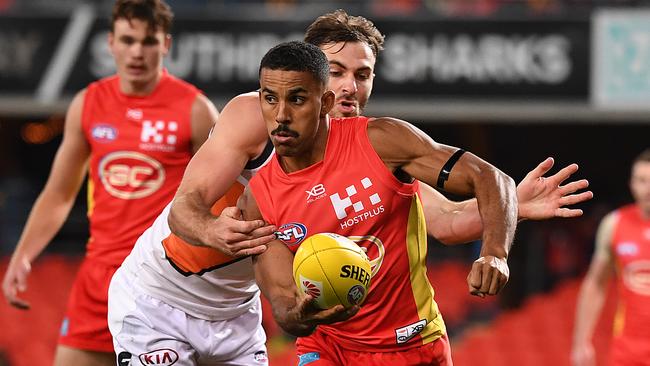 Touk Miller of the Suns under pressure from Jeremy Finlayson of the Giants during the Round 23 AFL match between the Gold Coast Suns and the GWS Giants at Metricon Stadium on the Gold Coast, Saturday, August 24, 2019. (AAP Image/Dave Hunt)