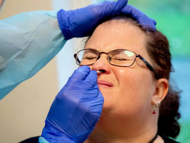 A nurse takes a nasal sample of a nursing aide for a rapid Covid-19 test before she can start her shift at a nursing home for elderly in Lerum, Sweden on December 18, 2020. (Photo by Adam IHSE / TT News Agency / AFP) / Sweden OUT