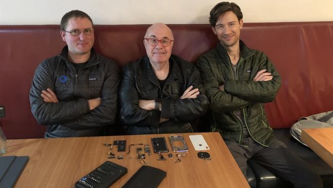 iFixit CEO Kyle Wiens (left), The Australian technology journalist Chris Griffith and iFixit's Jeff Souvanen inspect the components that make up an iPhone X at a coffee shop in Newtown, Sydney