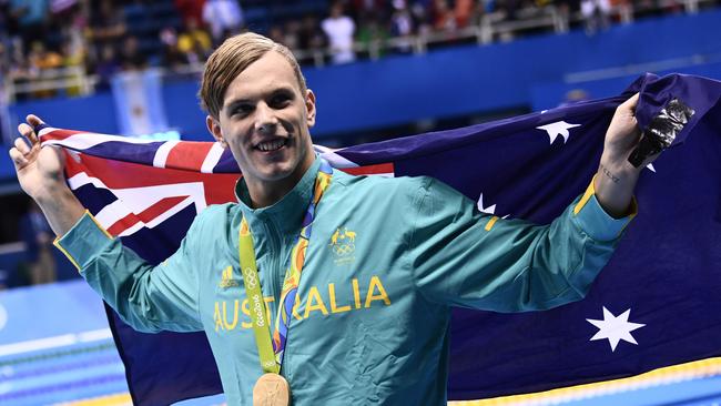 Australia's Kyle Chalmers waves his national flag during the Olympic medal ceremony of the Men's 100m Freestyle Final. Picture: AFP