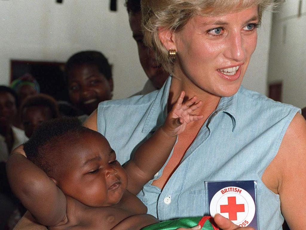 The trip will include stops to a site where Princess Diana famously cleared landmines. Pictured, the late Princess holds a baby in Angola. Picture: Tim Graham/Getty Images.