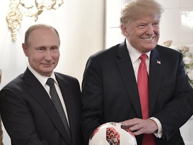 U.S. First Lady Melania Trump, left, Russian President Vladimir Putin, center, and U.S. President Donald Trump, pose with a soccer ball after a press conference following their meeting at the Presidential Palace in Helsinki, Finland, Monday, July 16, 2018. (Alexei Nikolsky, Sputnik, Kremlin Pool Photo via AP)