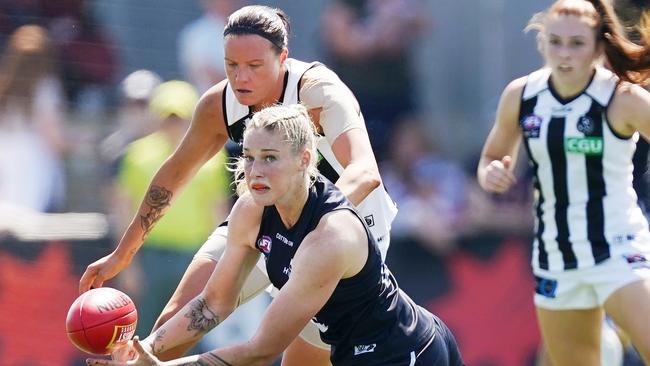 Tayla Harris fires off a handball in front of Collingwood defender Stacey Livingstone. Picture: AAP