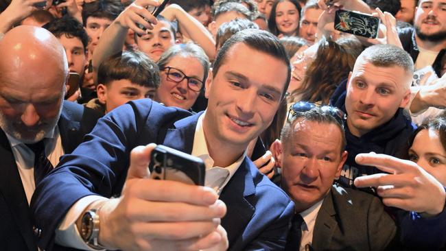 Jordan Bardella (C) poses for a selfie with supporters during a campaign rally in Montbeliard, eastern France. Picture: AFP.