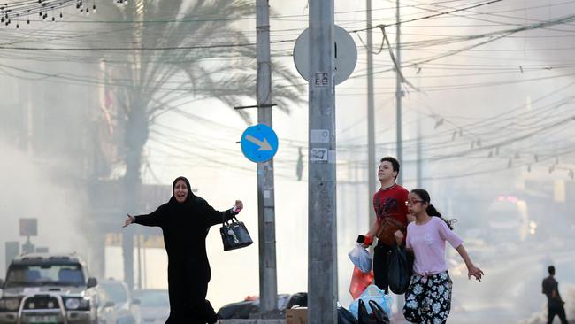 (Palestinians run for cover after a strike near the Al-Shifa hospital in Gaza City last November. Picture: AFP