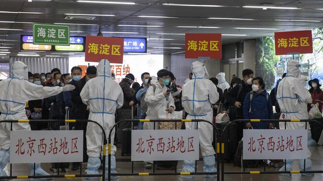 Passengers from Wuhan are sorted by district after they arrive on a high-speed train in Beijing on Sunday after a 76-day lockdown that contained them to the province where the virus originated. Picture: AP