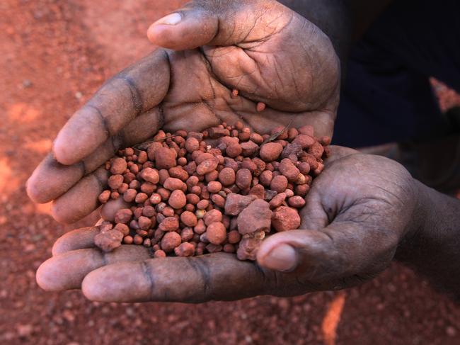 Aurukun Shire Council Mayor Neville Pootchemunka holding a handful of bauxite from the Rio Weipa mine