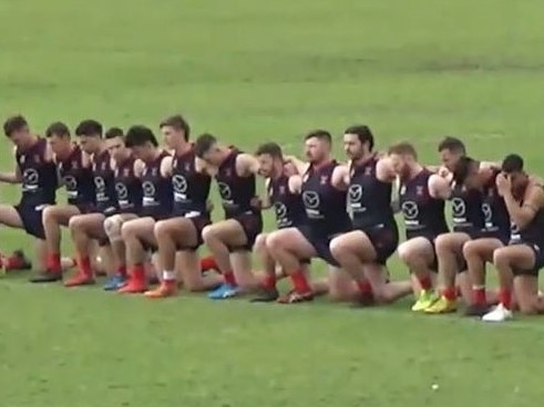 Pooraka Football Club players take a knee during the national anthem before Saturday's division five grand final.