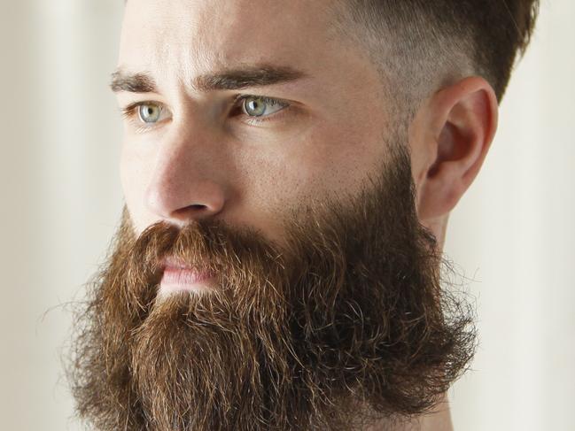 Bearded Caucasian man examining razorbeard generic thinkstock hipster shaver