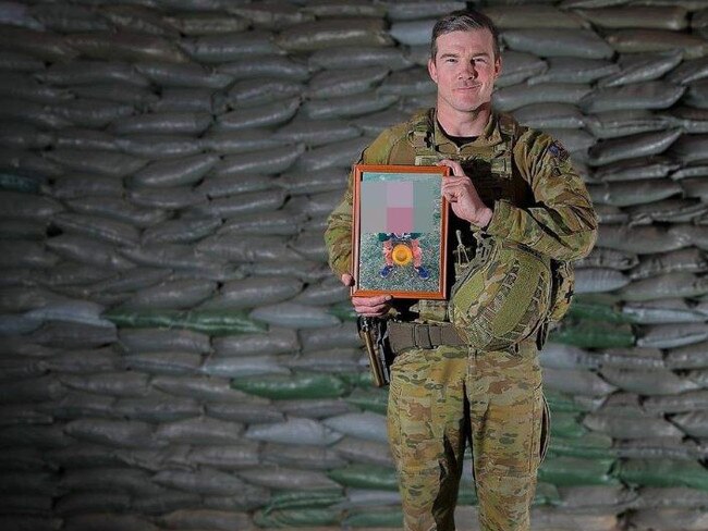 Lieutenant Colonel Sean Kearns holds a framed picture of his daughter in Afghanistan as part of a promotional push to portray the Army as family friendly. Picture: ADF