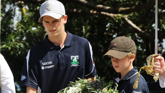 Scott and Oscar Cooper place a wreath on behalf of the Port Douglas Crocs Football Club in Anzac Park.