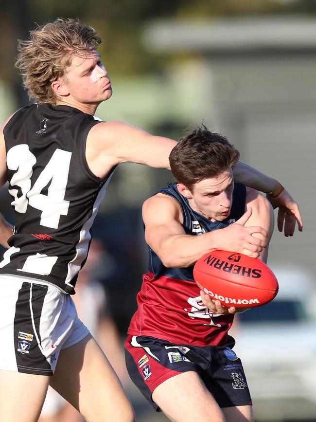 Sandhurst’s Charlie Robinson marks in front of Castlemaine’s Ryan Eyre.