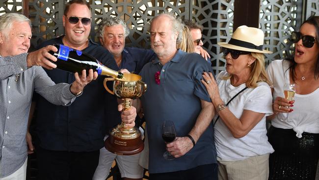 Twilight Payment owners Gerry Ryan, Nick Williams, Vin Sammartino, Michael and Sue Gudinski and Saskia Williams get their hands on their treasured prize at The Prince of Wales Hotel on Cup Day. Picture: Josie Hayden<br/>