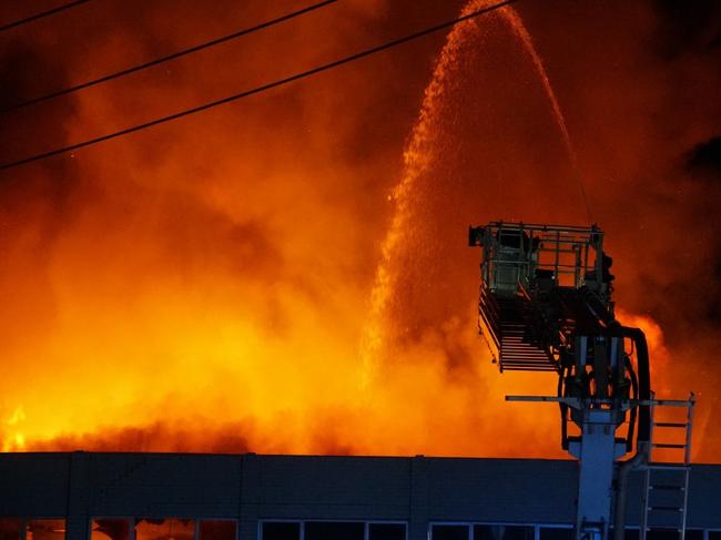 Firefighters battle flames as a massive inferno engulfs a furniture factory in Revesby overnight. Picture: Sydney Emergency