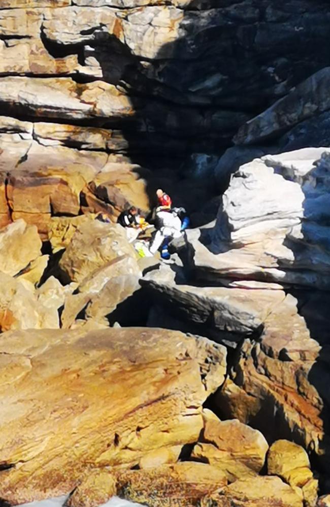 Emergency services scale the cliffs at Diamond Bay Reserve after a woman died after falling this morning.