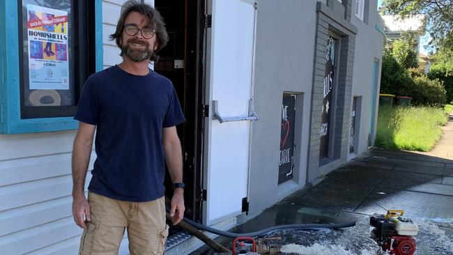 Mark Conaghan, the Committee President of the Pelican Playhouse Theatre Company, surveys water flooding the community theatre on Through Street, South Grafton.