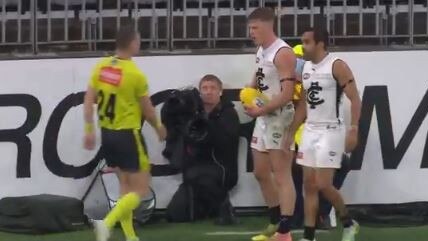 Jack Newnes remonstrates with the umpire over the cameraman's failure to move.