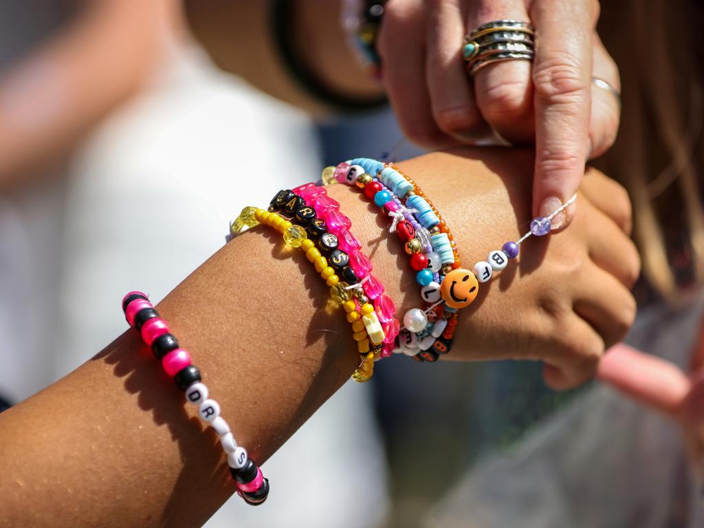 Taylor Swift fans also known as "Swifties" exchange friendship bracelets worn on their wrists as they arrive before Swift performs