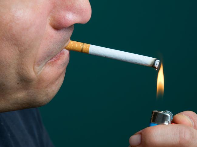 Man lighting cigarette with flame.