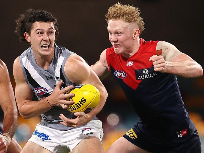 AFL Round 9. Melbourne vs Port Adelaide at the Gabba, Brisbane. 30/07/2020.  Darcy Byrne-Jones of the Power charges through the tacklers, Clayton Oliver  and Christian Salem of the Demons     . Pic: Michael Klein