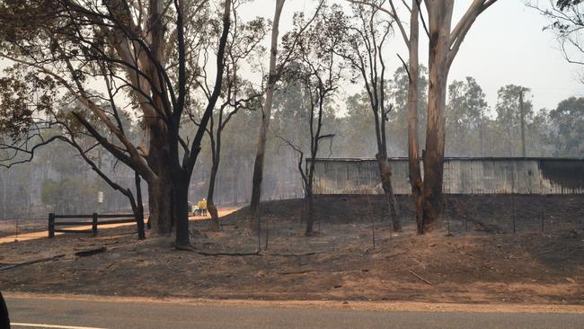 Fire crews section off a shed that was scorched by flames after a blaze passed through Nymboida, Clarence Valley.