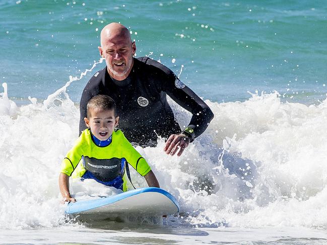 ### Gold Coast Bulletin only Please check with Picture Editor before use ###Pro surfer Bede Durbidge  teaching Broadbeach Kindy students about surfing and swim saftey at Broadbeach  beach.  Kai Long, 5, surfing.   Picture: Jerad Williams