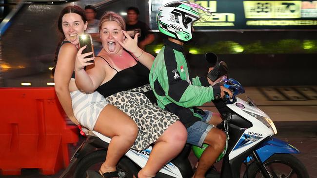 Two women ride on a scooter without helmets on. Picture: Liam Kidston