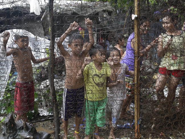 Children look on as police raid an alleged drug den in Manila. Picture: Aaron Favila
