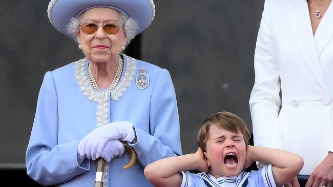 Britain's Prince Louis of Cambridge (R) holds his ears as he stands next to Britain's Queen Elizabeth II to watch a special fly-past. Picture: AFP