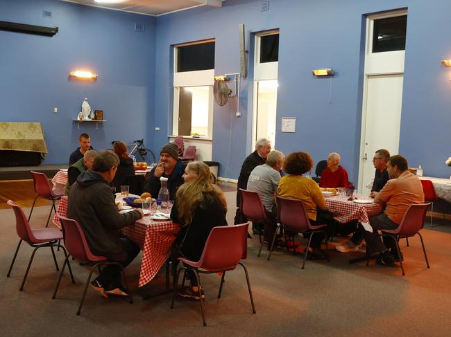 The group shares a meal and a chat at the Bondi charity. Picture: Richard Dobson