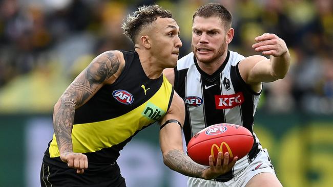 MELBOURNE, AUSTRALIA - MAY 07: Shai Bolton of the Tigers handballs whilst being tackled by Taylor Adams of the Magpies during the round eight AFL match between the Richmond Tigers and the Collingwood Magpies at Melbourne Cricket Ground on May 07, 2022 in Melbourne, Australia. (Photo by Quinn Rooney/Getty Images)