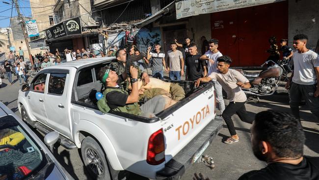 Palestinian militants surround a truck reportedly carrying a captured Israeli after crossing the border fence with Israel from Khan Yunis.