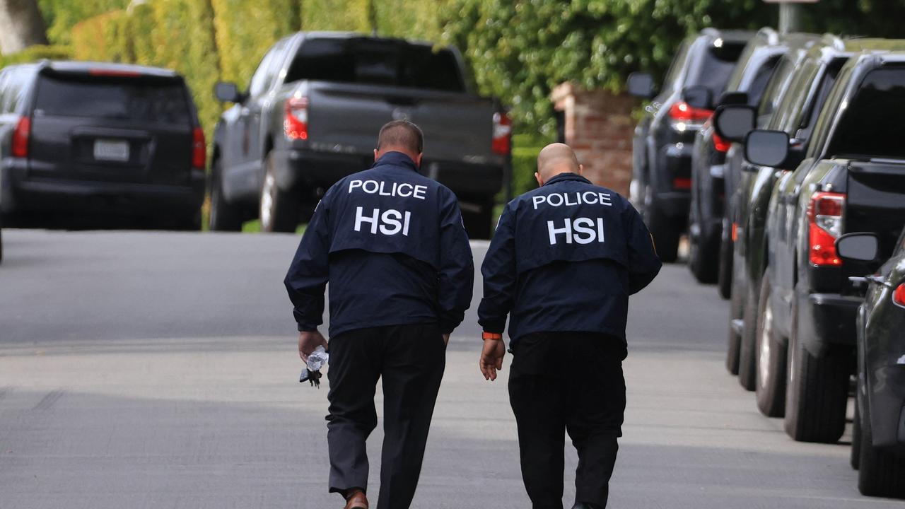 Homeland Security Ivestigations agents outside the home of Sean 'Diddy' Combs. Photo by David SWANSON / AFP.