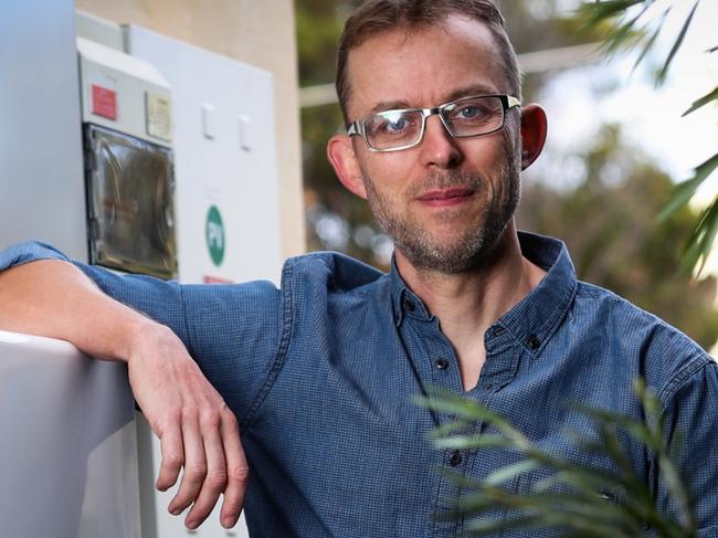 Solar Quotes founder and CEO Finn Peacock alongside his Tesla battery storage unit  at his house in Brighton. Photo: Kelly Barnes