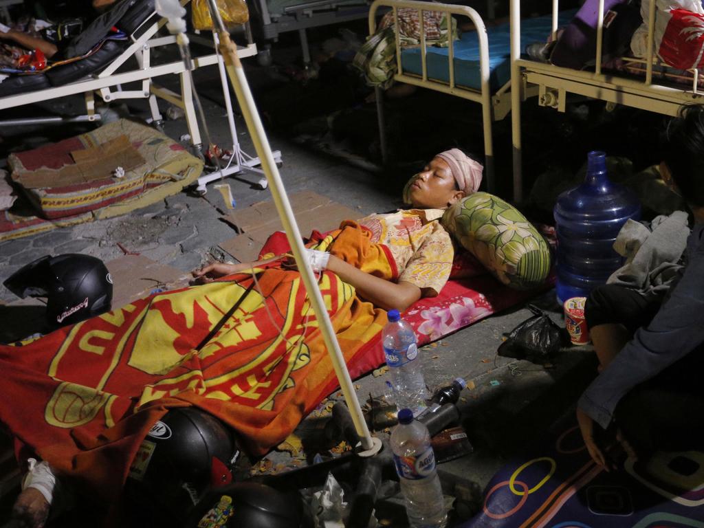 A woman lays while being treated outside an army hospital. Picture: AP