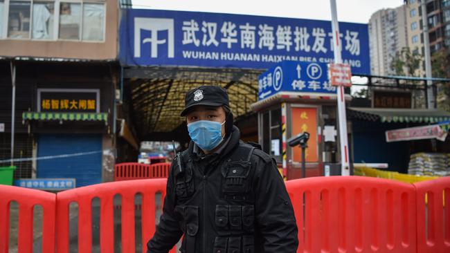 A police officer stands guard outside of Huanan Seafood Wholesale market in Wuhan in January 2020. Picture: AFP