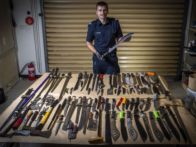 Senior Constable Lachlan McGillivray with some of the confiscated knives. Picture: Jake Nowakowski