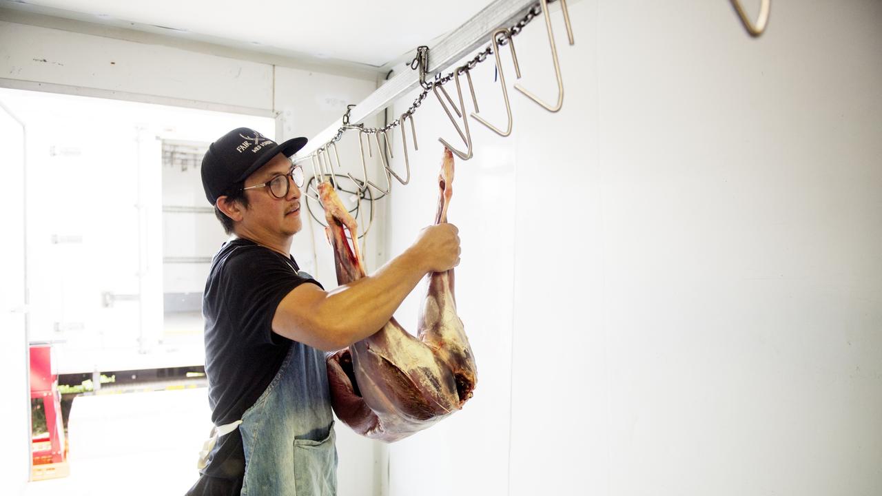 Jonas puts the carcass over the hooks in the processing room. Picture: Elise Derwin