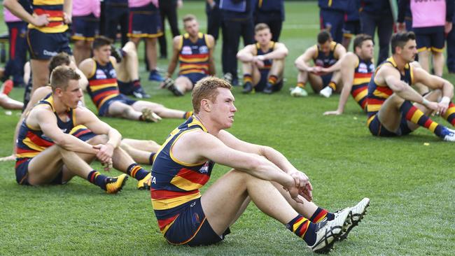 Adelaide’s Tom Lynch and team-mates sit while the Richmond players are presented with their 2017 premiership medals. Picture: Sarah Reed