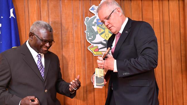 Solomon Islands Prime Minister Manasseh Sogavare reacts after he was presented a ukulele by Prime Minister Scott Morrison in Honiara in the Solomon Islands, in 2019. Picture: AAP