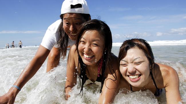 On the Gold Coast Sayaka Umezawa (left) teaches Japanese tourists Hiroko Enokida (middle) and Kayoko Taguchi the finer points of body surfing.